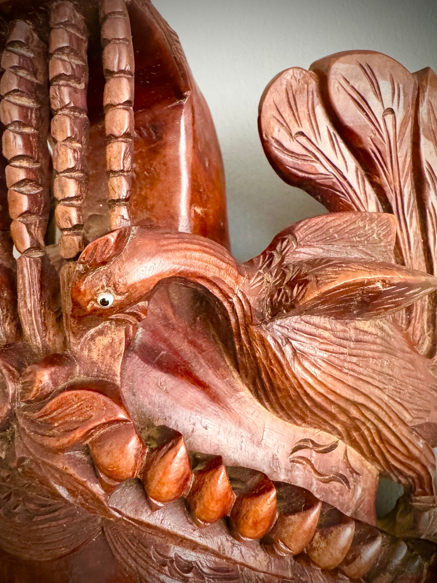This intricately detailed Chinese carved rosewood mask is truly captivating. The mask showcases a crown with a flaming pearl above a lotus flower, also flanked by two beautifully carved peacocks. The mask is enhanced with inset glass and enamel eyes. Remarkably, the mask retain its original eyes, and the wood is intact, which is very rare. the mask is mounted with a hanging bracket, the craftsmanship in the rosewood carving is absolutely exquisite.